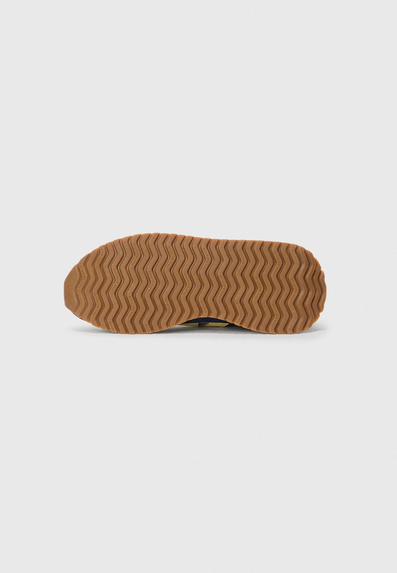 Rubberen schoenzool met een zigzagpatroon, in bruin kleur en met een gestructureerd oppervlak. Ontworpen voor grip en duurzaamheid.