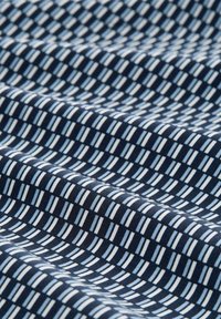 Marineblaues Gewebe mit einem geometrischen Muster aus abwechselnd hellblauen und weißen Rechtecken, das eine glatte Textur und gleichmäßige Webart aufweist.
