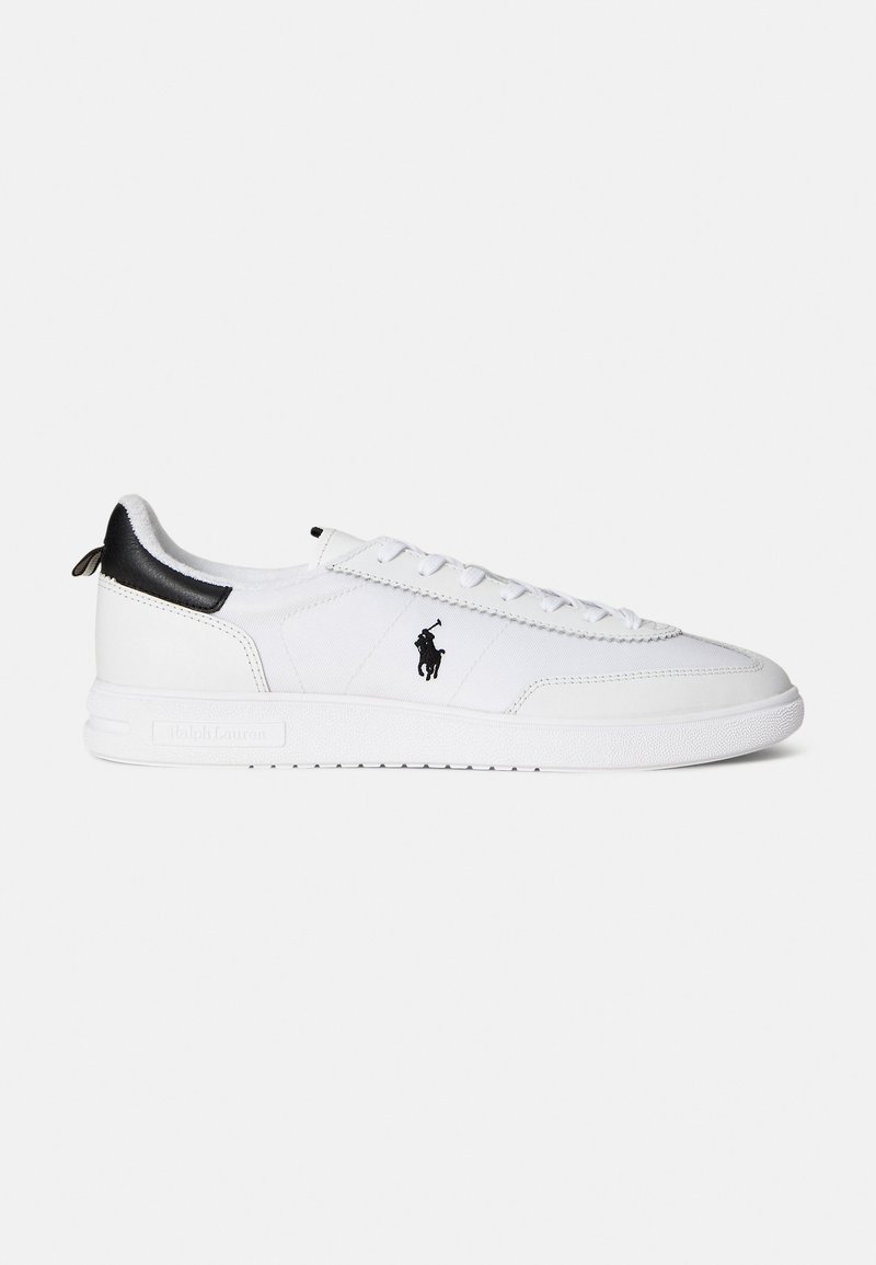 White sneaker made of leather and textile, featuring black accents, textured sole, and a logo on the side. Laces and padded collar included.