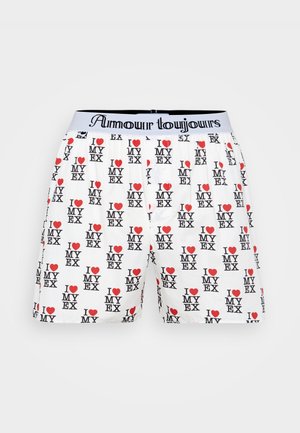 Bokserki wykonane z białej tkaniny z powtarzającym się nadrukiem "KOCHAM MOJĄ BYŁĄ" w kolorze czarnym i czerwonym, z czarnym pasem oraz metką "Amour toujours".