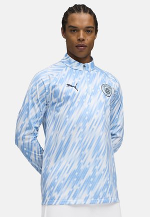 Lichtblauw sportshirt met een half-rits ontwerp, voorzien van diagonale strepen in verschillende tinten, en een zwart Puma-logo en embleem op de borst.