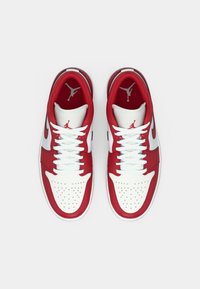 Ténis Nike Air Jordan vermelhos e brancos vistos de cima, mostrando os atacadores, caixas de bico perfuradas e logótipos Jumpman dentro.