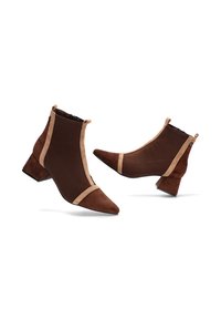 Botines marrones hasta el tobillo con punta afilada, fabricados en ante y tela, con ribete beige a los lados y tacón bajo de bloque.