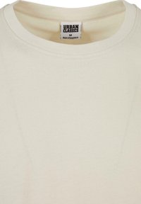 Beige bomulds t-shirt med rund halsudskæring. Har et lille mærke med teksten "URBAN CLASSICS" og størrelse "M". Minimalistisk design, glat tekstur.