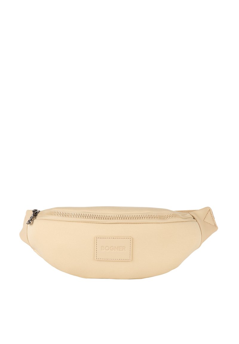 Beżowa nerka o gładkim, matowym wykończeniu. Wyposażona w zamek błyskawiczny oraz małe wytłoczone logo z przodu. Kompaktowy i smukły design.