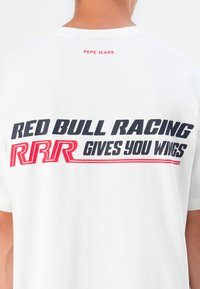 Hvit bomulls t-skjorte med "RED BULL RACING RRR GIVES YOU WINGS" i fete svarte og røde bokstaver på baksiden, med "PEPE JEANS" logo over.