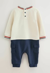 Twee-delig outfit met een crèmekleurige top en een marineblauwe onderkant. De top heeft een ronde gestreepte kraag; de onderkant heeft cargozakken en elastische manchet.