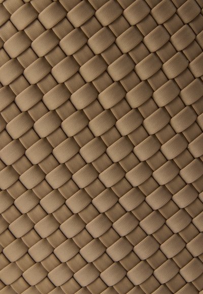 Υφαντό υλικό σε μπεζ τόνο, με σχέδιο που παραπέμπει σε πλέγμα με στρογγυλεμένες, ανυψωμένες περιοχές, δημιουργώντας μια υφασμάτινη επιφάνεια.