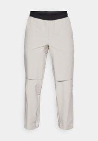 Világosszürke cargo nadrág fekete elasztikus derékkal, két oldalsó zsebbel és laza fazonnal. Sima textúra, egyenes lábú kialakítás.