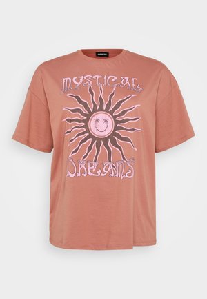 Roze oversized t-shirt met een zonontwerp en roze accent tekst met de tekst "Mystical Dreams." Korte mouwen en ronde halslijn.