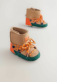 Tannfarbene und grüne Kleinkinderstiefel mit orangefarbenen Schnürsenkeln und einer strukturierten Ferse. Sie verfügen über ein weiches Innenfutter und ein Logoetikett. Abgerundetes Zehendesign.