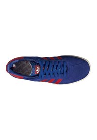 Blue suede sneaker with red stripes, round toe, flat laces, and a patterned insole. Rubber sole for traction.