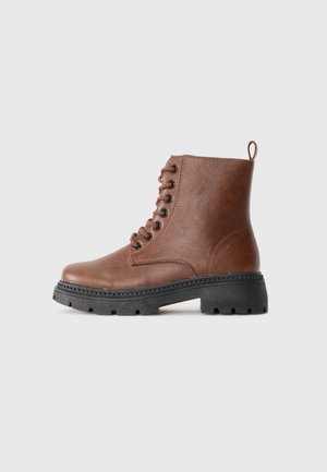 Bottines en cuir marron à lacets avec semelle noire robuste et languette à l'arrière, présentées sur un fond blanc uni.