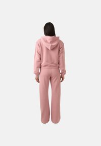 Rožinė dziewka ir atitinkamos plačios kelnės, pagamintos iš švelnaus audinio. Savybėse – raištelis ant kapučino ir gumbeliai ant rankovių, užtikrinantys laisvą prigludimą.