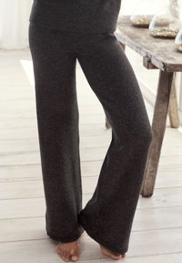 Dunkelgraue, weit geschnittene Hose aus weichem, strukturiertem Stoff. Verfügt über einen gestrickten Bund und endet unter dem Knöchel, mit einer lässigen Passform.