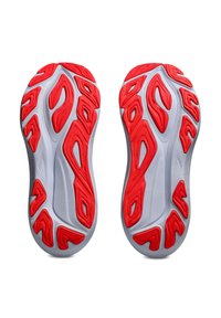 Shoe soles in white with red accents, featuring a textured surface and ergonomic cutouts for flexibility and grip.