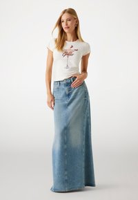 Witte T-shirt met een geprint ontwerp van een cocktailglas, gecombineerd met een lange, lichtblauwe denimrok, met een rechte snit en zichtbare stiksels.