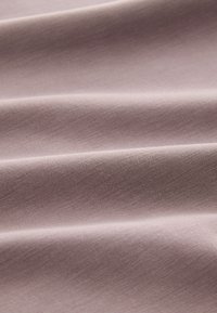 Tessuto morbido e leggero di colore malva chiaro, con una trama liscia, che presenta pieghe delicate e una sottile lucentezza, adatto a diverse applicazioni tessili.