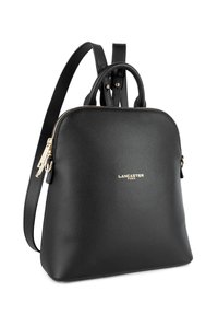 Sac à dos en simili cuir noir avec une forme arrondie, fermeture éclair en ton doré et accents en métal, comportant une poignée supérieure et des bretelles ajustables.