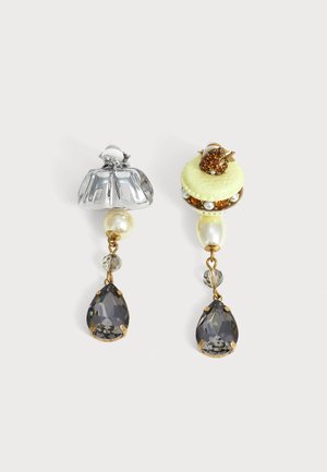 Boucles d'oreilles pendantes dépareillées avec perle, perles jaunes et ambre, coiffe florale en argent sur l'une, et disque vert avec détail de baie en ambre sur l'autre.