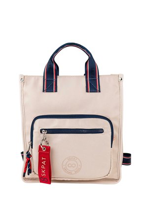 Bolso tote de tela beige con detalles en azul oscuro, un bolsillo frontal con cremallera, asas superiores y una etiqueta roja desmontable. Cuenta con un detalle de logo circular.