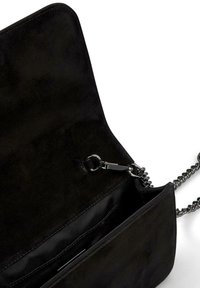 Czarna torebka zamszowa z łańcuszkowym paskiem; wnętrze zawiera jedną przegrodę oraz kieszeń na zamek. Gładka tekstura i minimalistyczny design.
