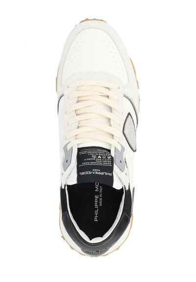 Sneaker bianca con lacci crema, dettagli neri e una toppa logo grigia. Presenta materiali in suede e pelle, un'intersuola testurizzata e punta perforata.