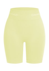 Hoge taille fietsbroek in lichtgeel, gemaakt van gladde, rekbare stof. Kenmerkt zich door witte tekst "SMILE" langs de tailleband.