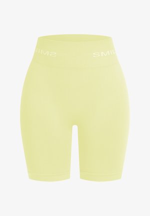 Cortos de bicicleta de cintura alta en amarillo claro, hechos de material suave y elástico. Presenta el texto en blanco "SONRÍE" a lo largo de la cinturilla.