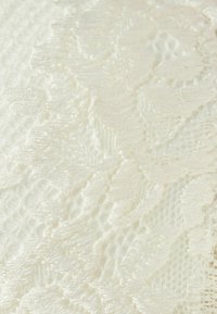Spets tyg i off-white med intrikata blommönster, texturerade vävar och en delikat finish. Mjuk, lätt vikt.