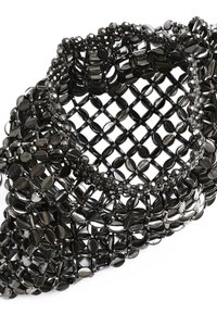 Bracciale nero di perline con un motivo intrecciato texturizzato, composto da perle ovali e rotonde, arricchito da dettagli di perline sfaccettate.