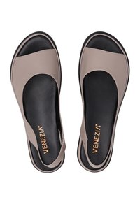 Beige syntetiske sandaler med rund tådesign, sort tekstureret sål og subtil branding i guld. Flad sål og åbne sider.