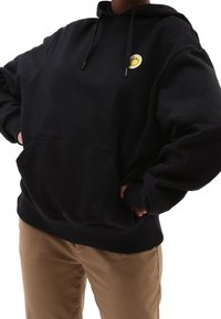 Sudadera negra con bolsillo frontal y capucha con cordón. Presenta un gráfico de una sonrisa amarilla en la parte superior izquierda. Material de mezcla de algodón.