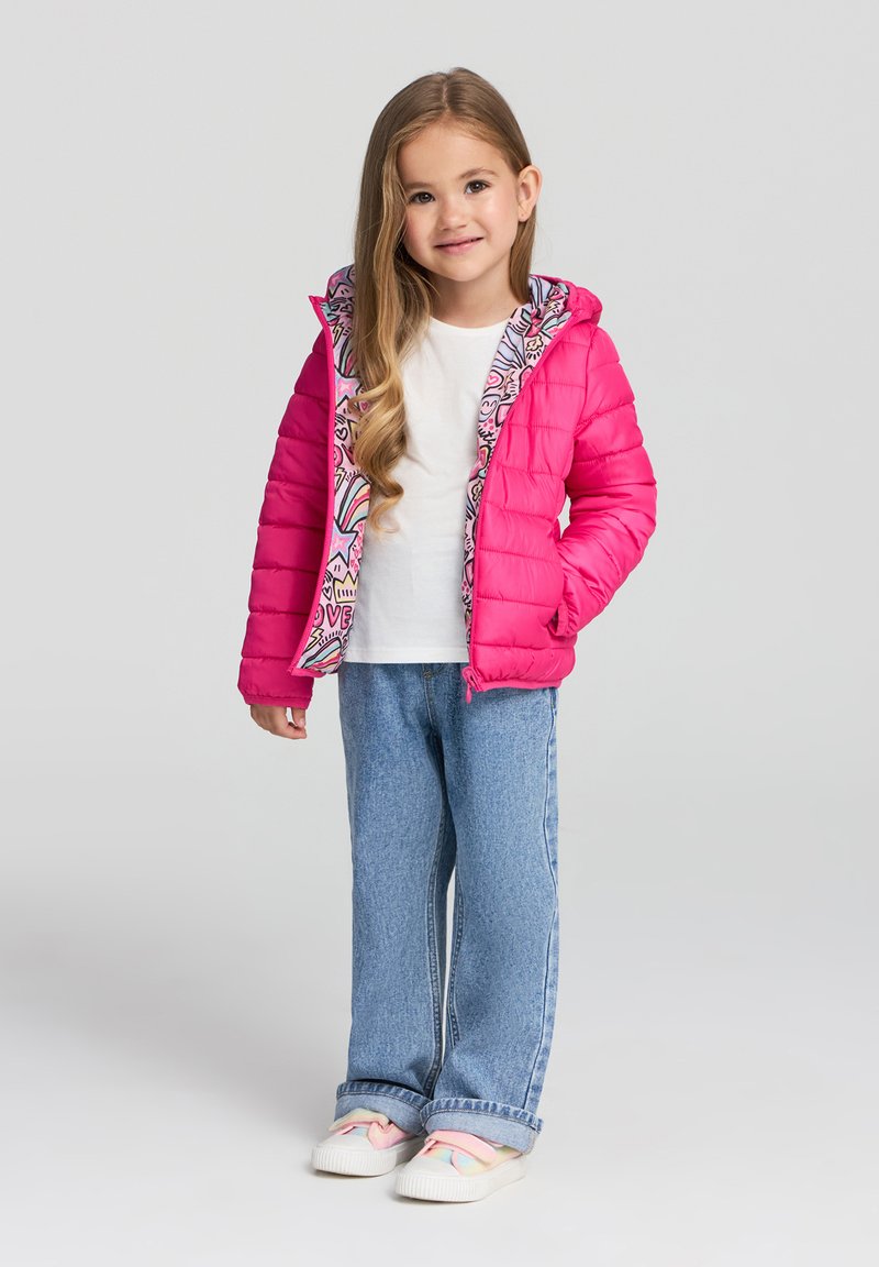 Giacca a vento rosa con design trapuntato, fodera a fantasia, t-shirt bianca, jeans blu e scarpe slip-on con accenti pastello.