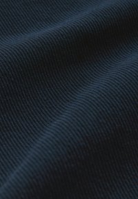 Tejido de canalé azul marino con una superficie texturada, que presenta finas líneas verticales y una apariencia suave y ligeramente elástica.