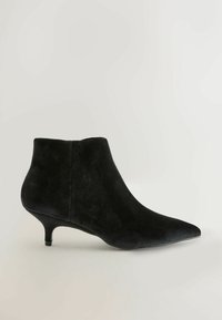 Stivaletto in suede nero con punta affusolata, tacco corto e texture liscia. Presenta un design semplice e snello senza decorazioni.