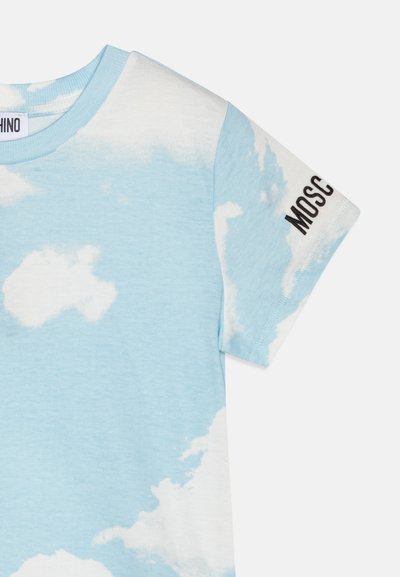 Ljusblå T-shirt med vita molnmönster. Har en rundad halsringning och svart "MOSCHINO"-text på vänster ärm. Tillverkad i bomull.