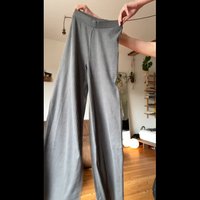 Gray wide-leg pants with vertical ribbed texture, a thick elastic waistband, and no visible fasteners. Suitable for casual wear.