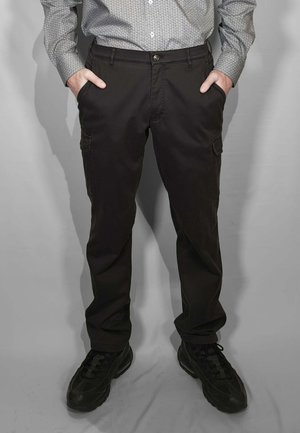 Pantaloni cargo neri a vestibilità slim, con tasche laterali, chiusura frontale con bottoni e texture liscia. Indossati con scarpe sportive nere.