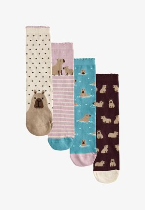 Vier bunte Socken mit Capybara-Motiven: großes Capybara-Gesicht, zwei Capybaras auf Streifen, schwimmende Capybaras auf Blau und mehrere sitzende Capybaras.