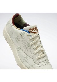 Baskets de couleur crème avec motifs en relief, superposition texturée et col rembourré multicolore. Dotées de lacets plats et d'une semelle en caoutchouc.