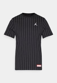 Camiseta de manga corta negra con finas rayas verticales blancas, un logo blanco de Jumpman en el pecho y una pequeña etiqueta roja cerca del dobladillo.