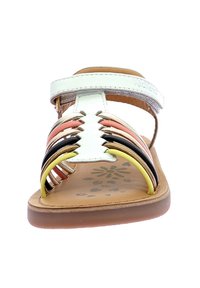 Sandalias con tiras y un empeine blanco, que presentan bandas tejidas multicolores en rosa, naranja, negro y amarillo, y una plantilla de color marrón texturizada.