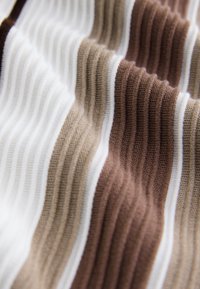 Ribbed fabric in alternating stripes of white, light brown, medium brown, and dark brown. Soft texture with a wavy appearance.