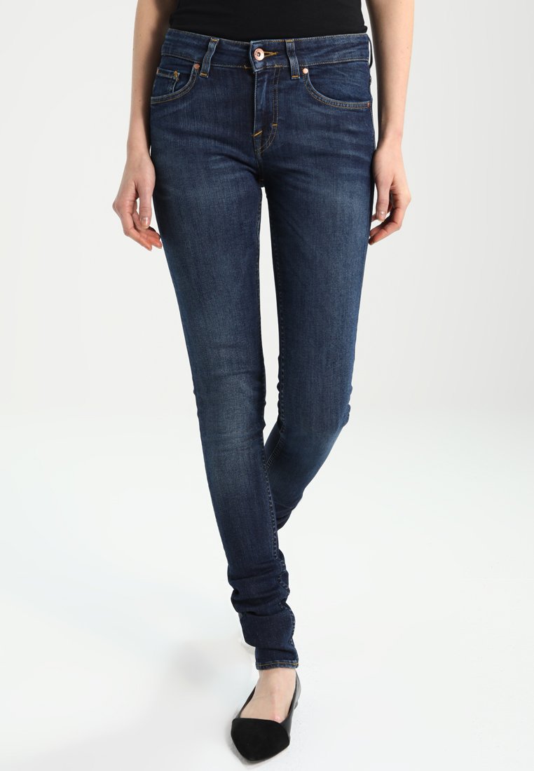 Skinny jeans in donkerblauwe denim met een gladde textuur. Voorzien van een vijf-pocket ontwerp, contrasterende stiksels en koperen hardware details.