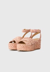 Sandales plateforme espadrilles tissées roses avec bout ouvert, straps entrecroisés et boucle à la cheville. Semelle en fibre naturelle texturée pour une meilleure adhérence.