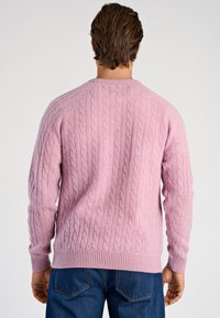 Cablestickad tröja i mjuk rosa färg, med rund halsringning, ribbade muddar och fåll samt texturerat mönster på ryggen.