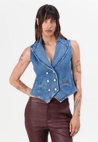Denim-viitta, sininen väri, räätälöity malli. Varusteena huippukuvio, tuplapainikekiinnitys ja kaksi etutaskua.