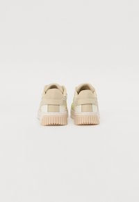 Beige Sneakers mit einer strukturierten Oberseite, kontrastierenden Netz-Einsätzen und einer genoppten Gummisohle. Verfügt über minimales Branding an der Ferse und den Seiten.