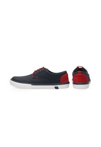 Marineblaue Freizeitschuhe mit roten Wildlederakzenten, durchlöchertem Blatt, weißer Gummisohle und roten Schnürsenkeln. Sie haben ein niedriges Profil und eine abgerundete Zehenpartie.